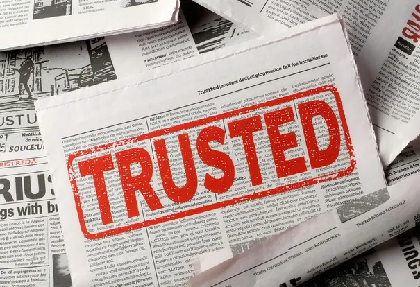 a lot of newspapers, one has a "TRUSTED" stamp in red ink on it